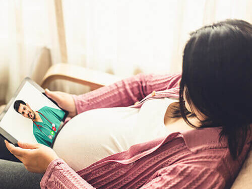 Pregnant woman having a video call on a tablet.