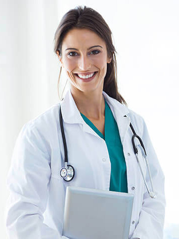 Female doctor smiling, holding a digital tablet, with a stethoscope around her neck.